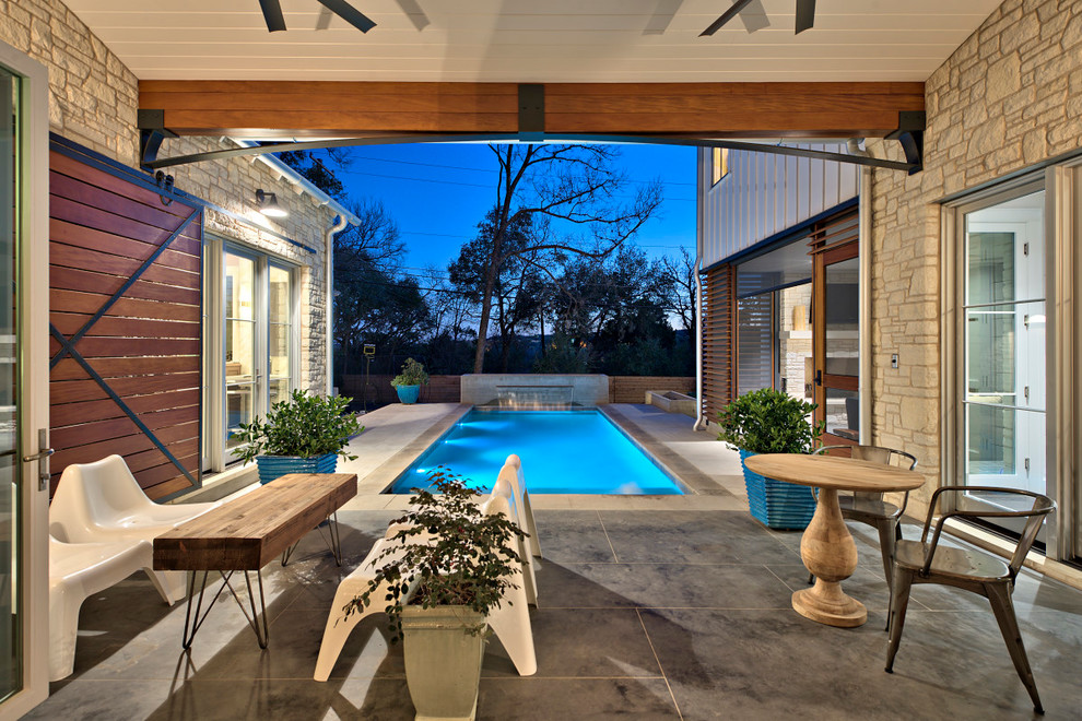 Immagine di una grande piscina monocorsia tradizionale rettangolare dietro casa con fontane e cemento stampato