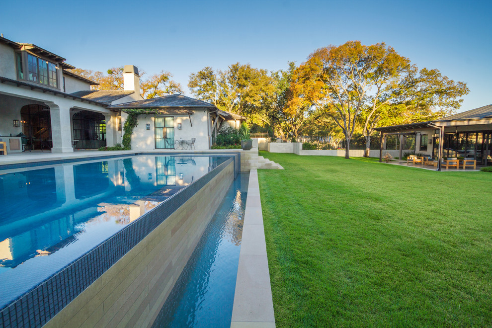 Photo of a medium sized mediterranean back rectangular lengths swimming pool in Austin with a water feature and concrete paving.