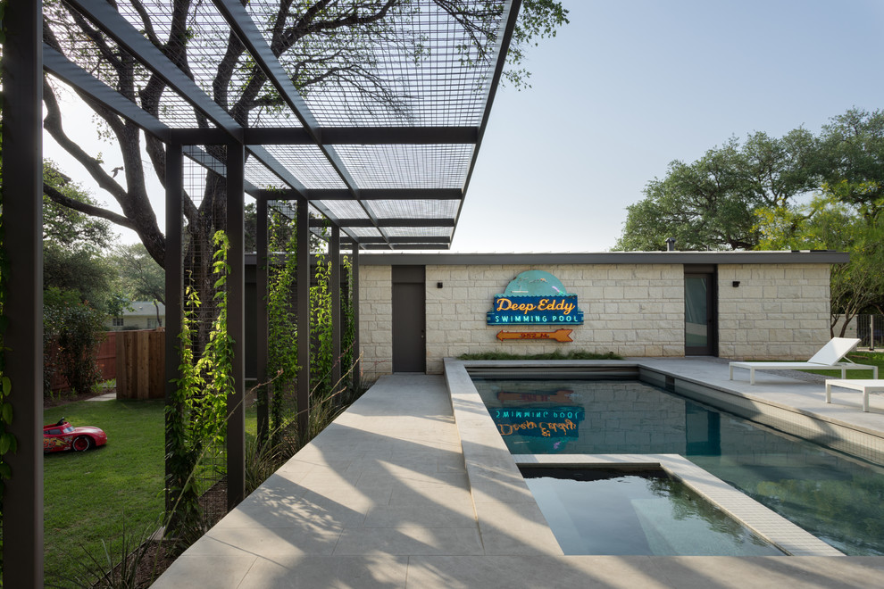 На фото: большой прямоугольный бассейн на внутреннем дворе в современном стиле с покрытием из каменной брусчатки с