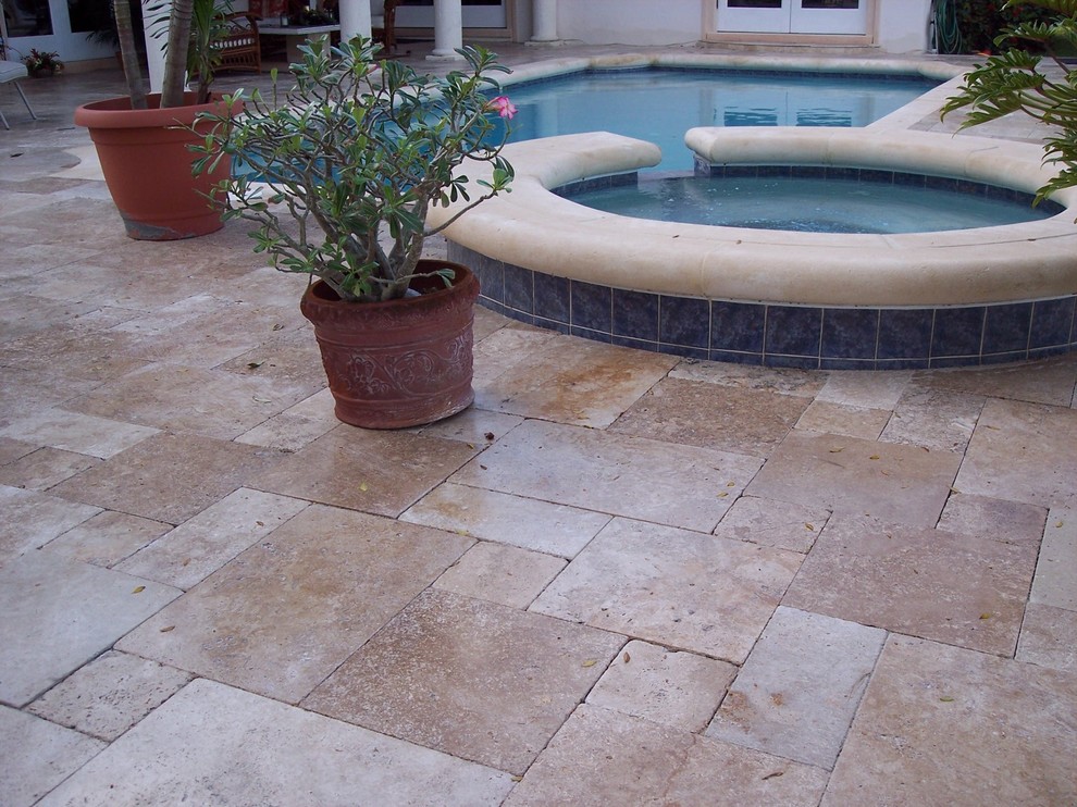 Foto di una piscina tropicale rettangolare di medie dimensioni e dietro casa con pavimentazioni in pietra naturale