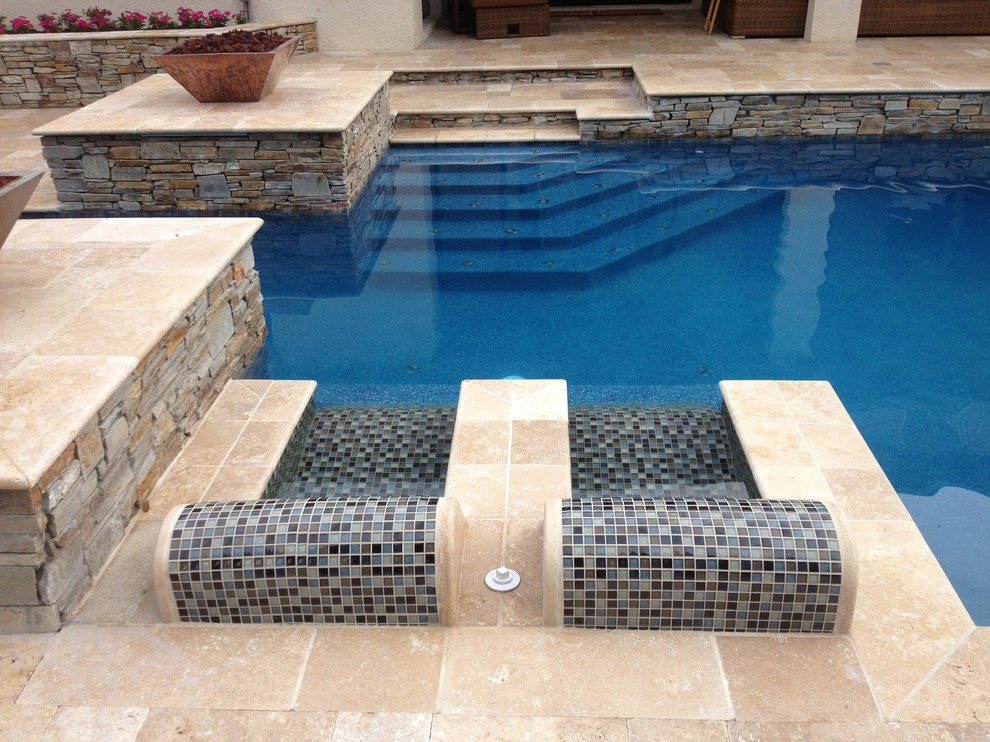 Example of a large tuscan backyard stone and custom-shaped lap pool fountain design in Other