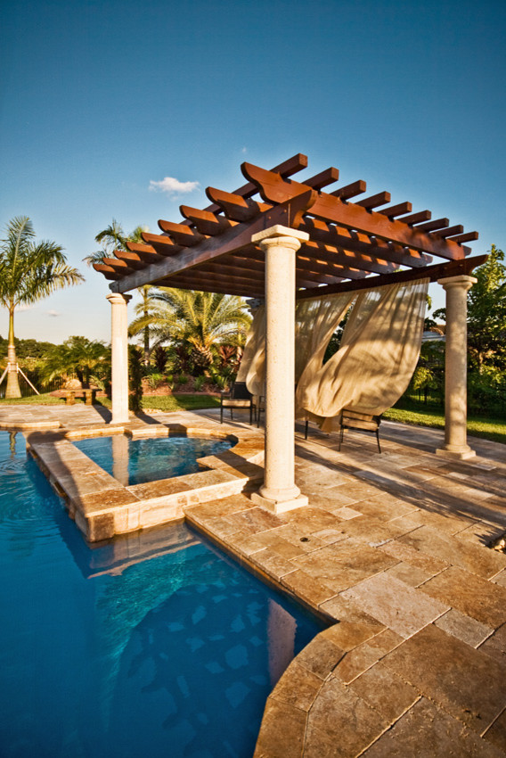 Идея дизайна: большой бассейн произвольной формы на заднем дворе в морском стиле с джакузи и покрытием из каменной брусчатки