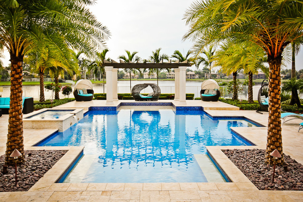 Foto de piscinas y jacuzzis mediterráneos grandes a medida en patio trasero con adoquines de piedra natural