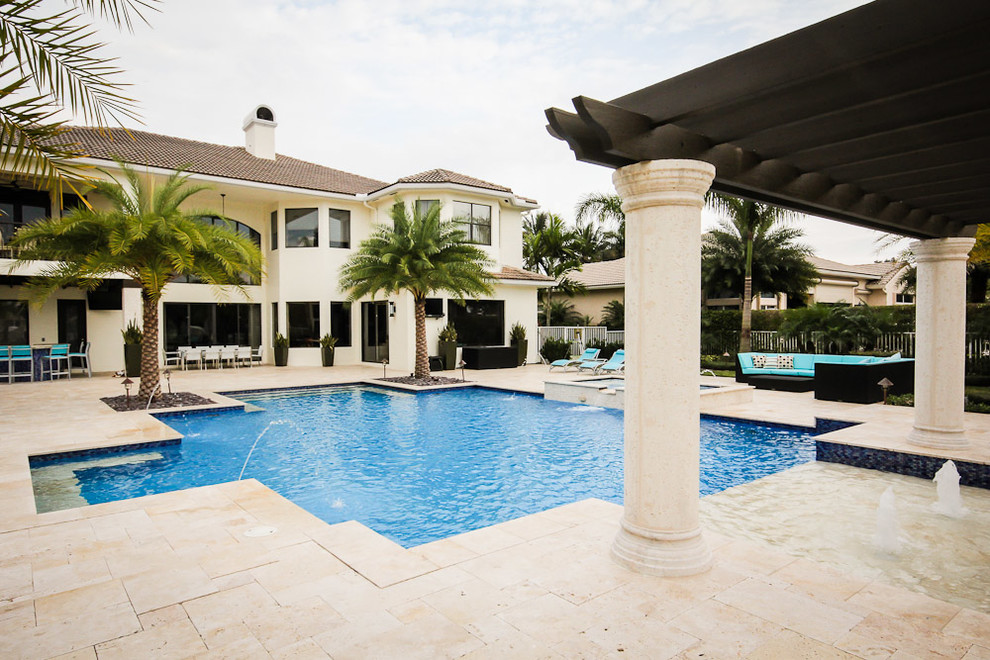 Diseño de piscinas y jacuzzis mediterráneos grandes a medida en patio trasero con adoquines de piedra natural