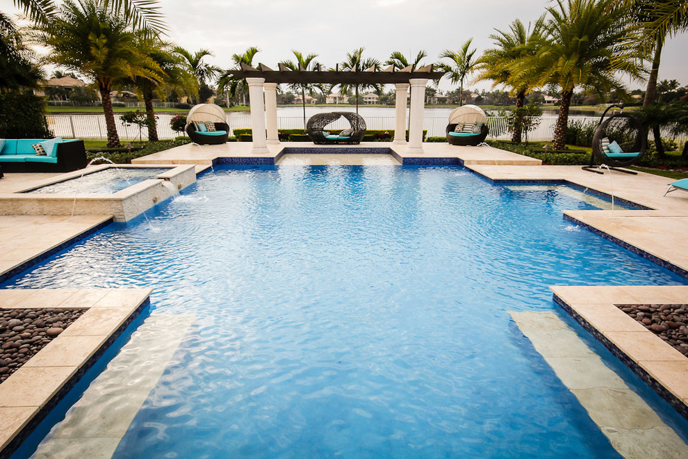 Пример оригинального дизайна: большой бассейн произвольной формы на заднем дворе в средиземноморском стиле с джакузи и покрытием из каменной брусчатки