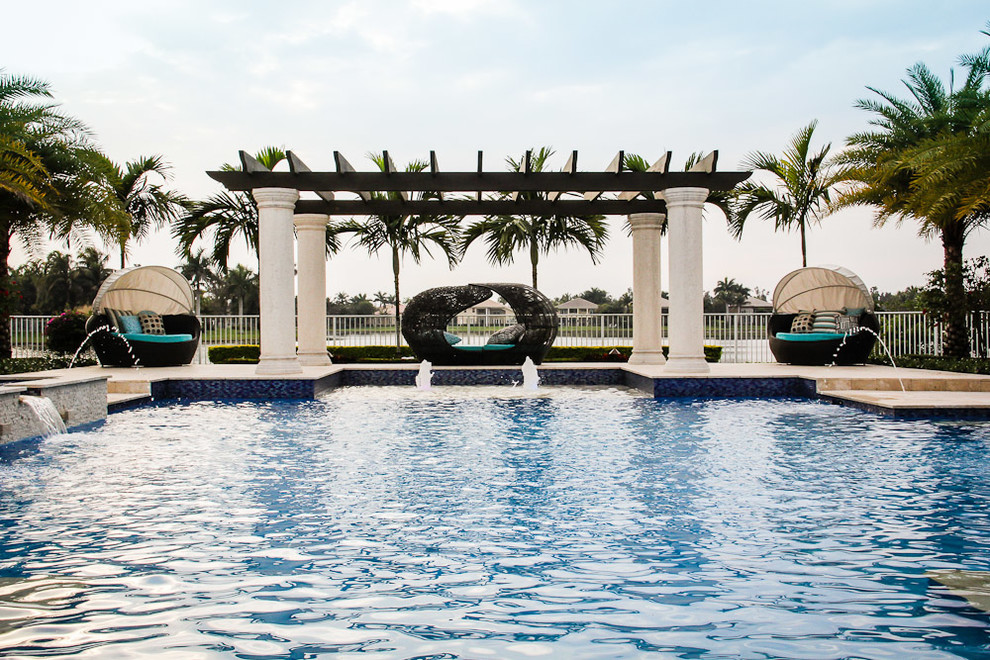 Стильный дизайн: большой бассейн произвольной формы на заднем дворе в средиземноморском стиле с джакузи и покрытием из каменной брусчатки - последний тренд