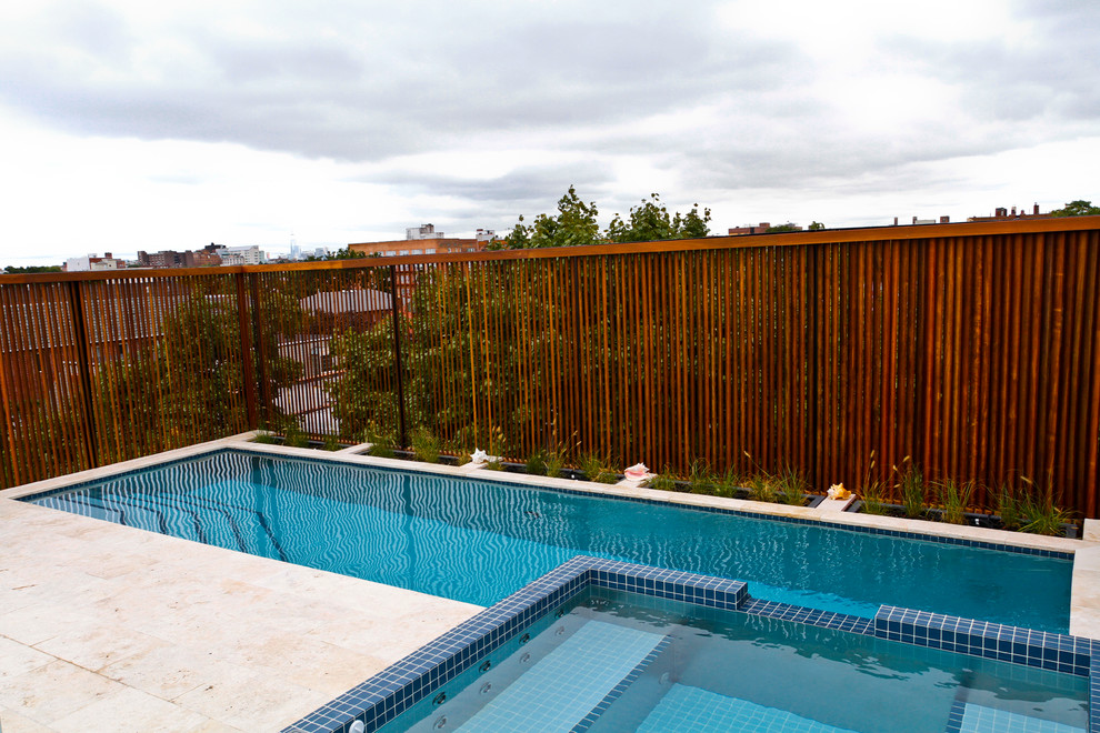 Exemple d'une piscine sur toit moderne rectangle avec un bain bouillonnant.