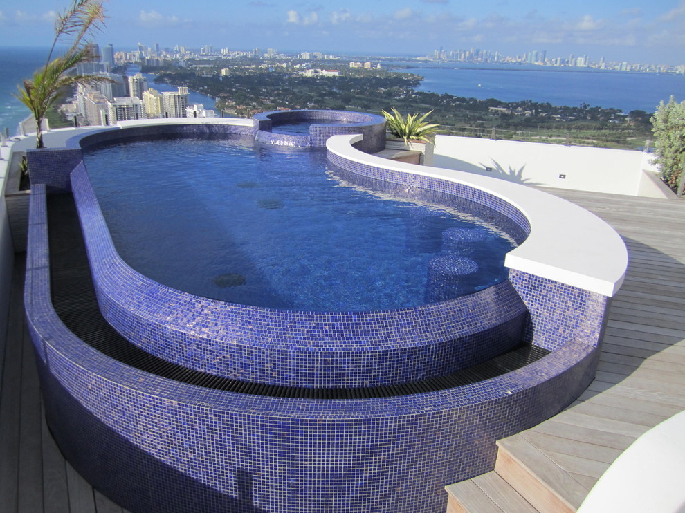 Cette image montre une piscine sur toit à débordement design sur mesure avec un bain bouillonnant et une terrasse en bois.