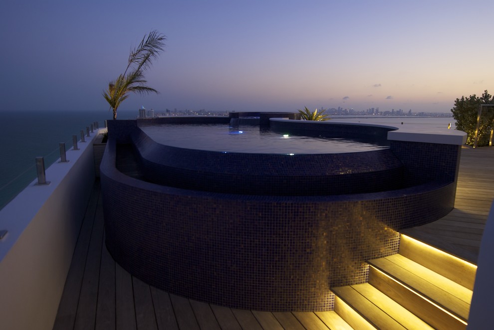 Inspiration for a contemporary rooftop custom-shaped infinity hot tub remodel in Miami with decking