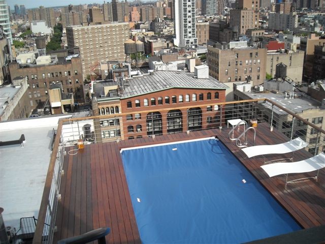 Immagine di una piscina monocorsia tradizionale rettangolare di medie dimensioni e sul tetto con pedane