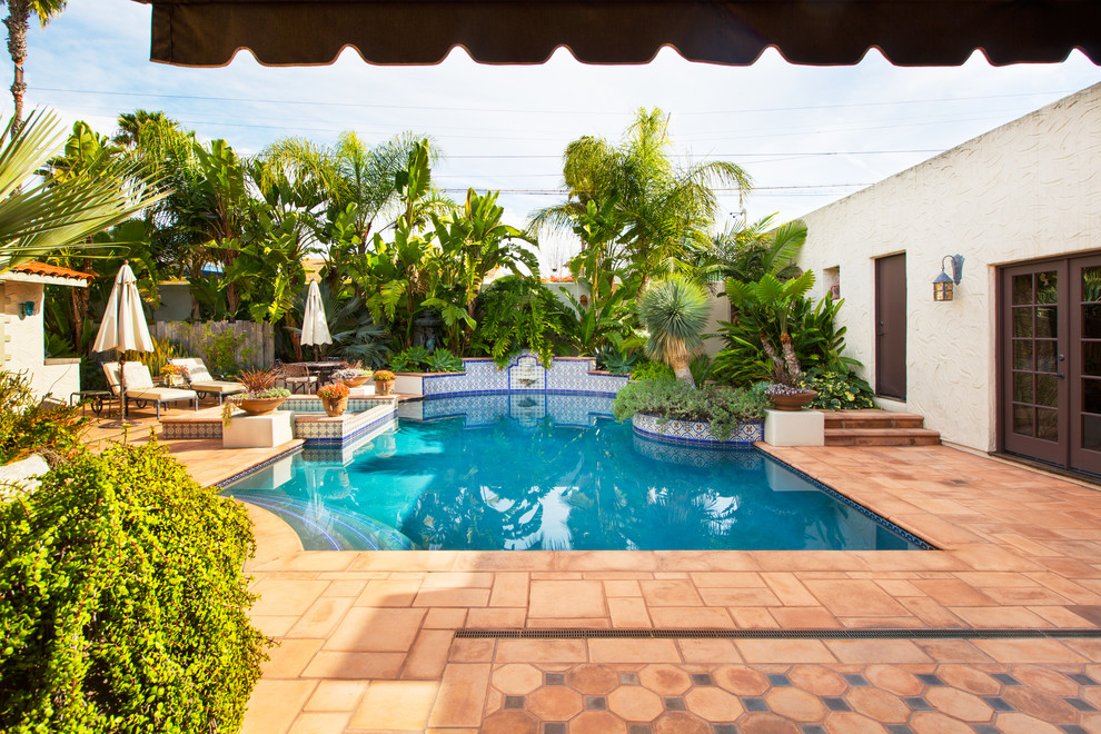 Modelo de piscinas y jacuzzis alargados mediterráneos de tamaño medio rectangulares en patio trasero con adoquines de hormigón