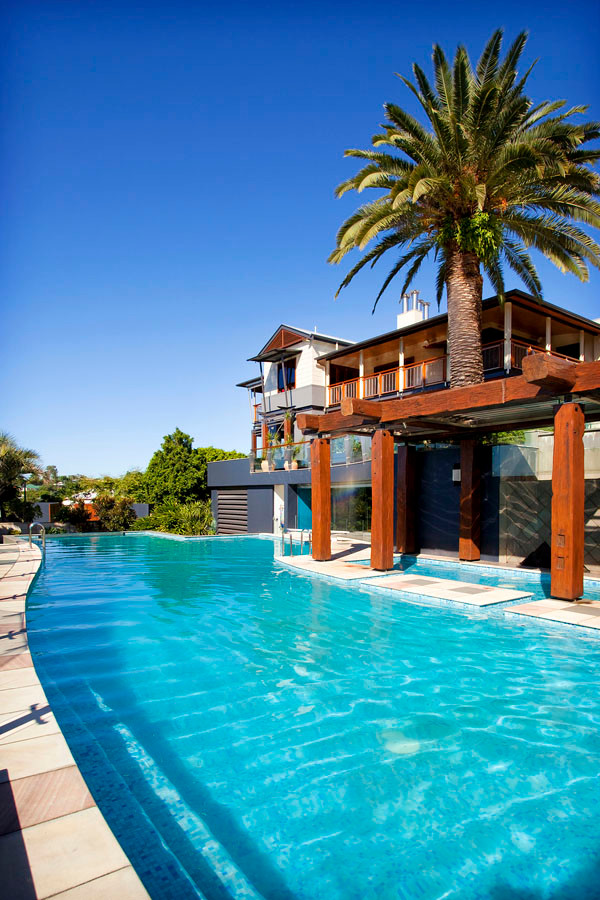 Imagen de piscina clásica renovada extra grande a medida en patio trasero con adoquines de piedra natural