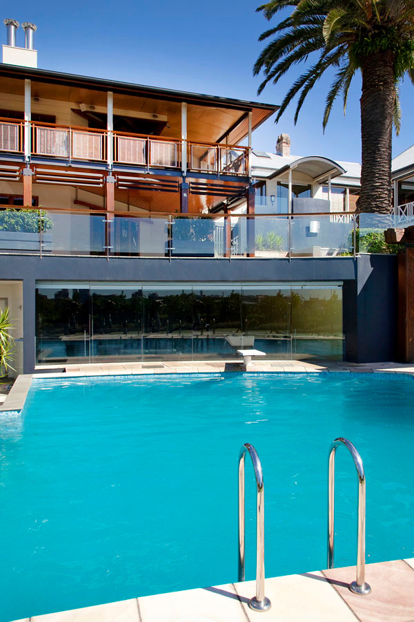 Inspiration for an expansive traditional back custom shaped swimming pool in Brisbane with natural stone paving.