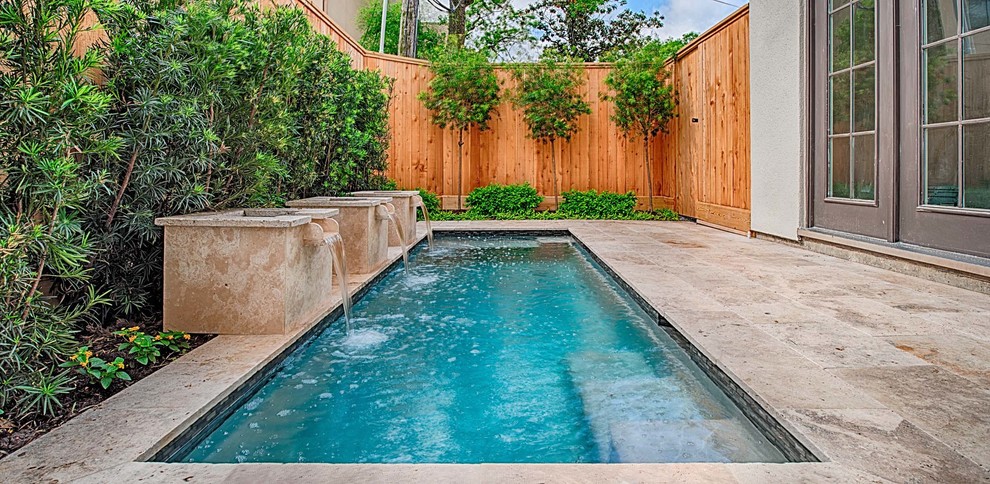 Ejemplo de piscina con fuente actual pequeña rectangular en patio trasero con adoquines de piedra natural