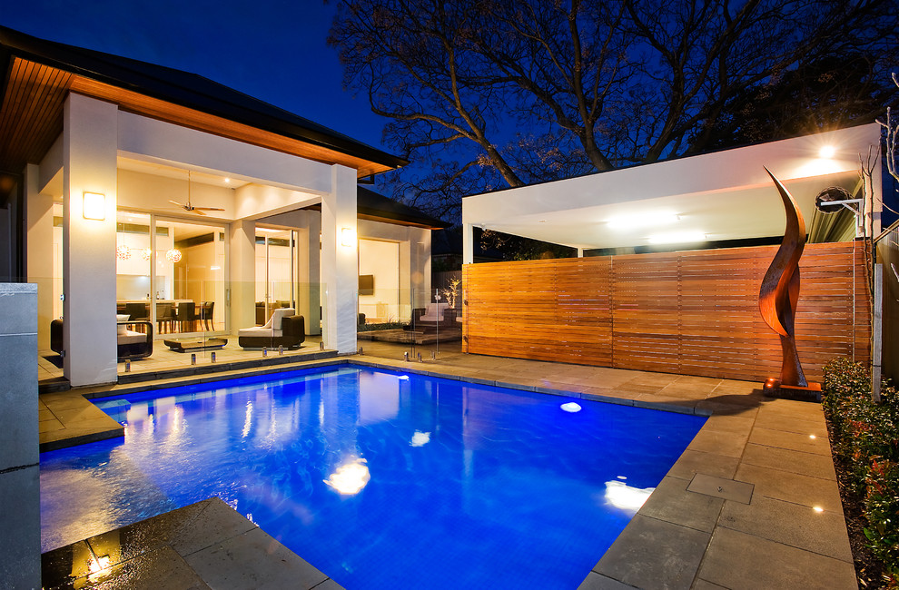 Diseño de piscina actual de tamaño medio a medida en patio trasero