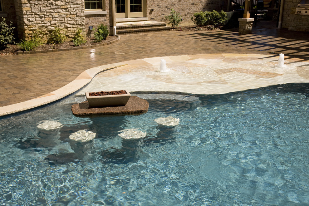 Pool - large tropical backyard brick and custom-shaped pool idea in Chicago