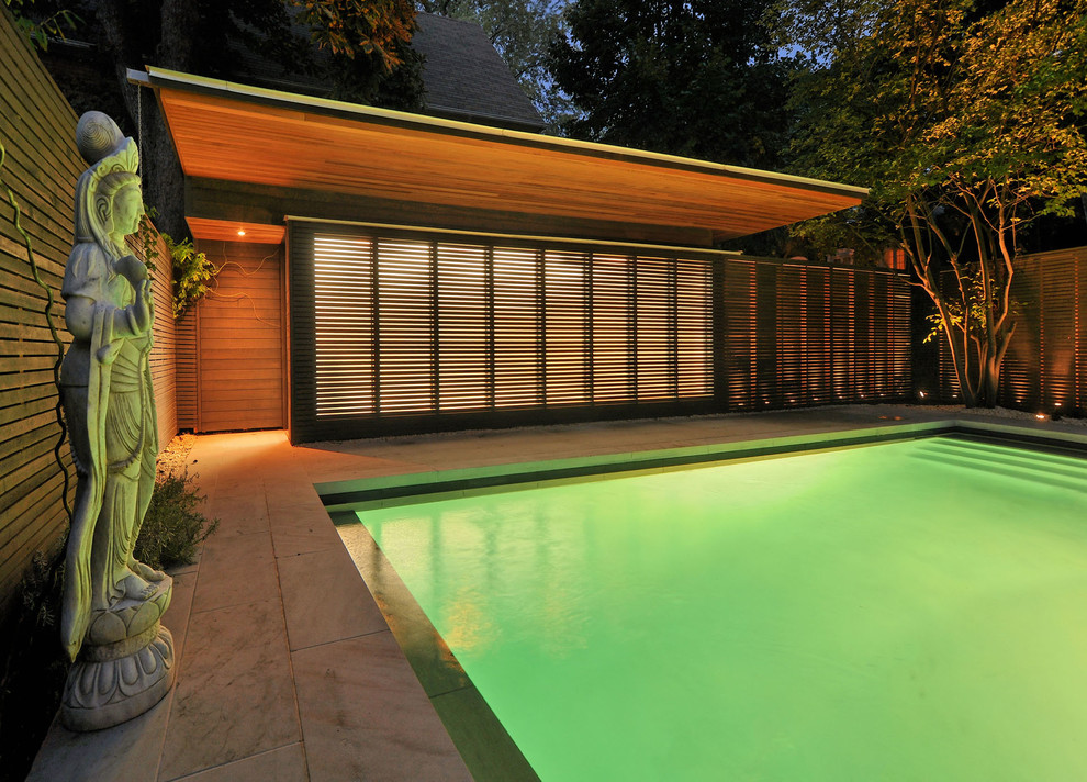 На фото: спортивный, прямоугольный бассейн среднего размера на заднем дворе в стиле модернизм с покрытием из каменной брусчатки