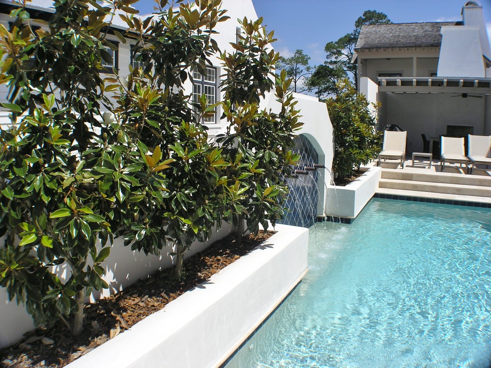На фото: маленький прямоугольный бассейн на внутреннем дворе в средиземноморском стиле с покрытием из плитки и фонтаном для на участке и в саду