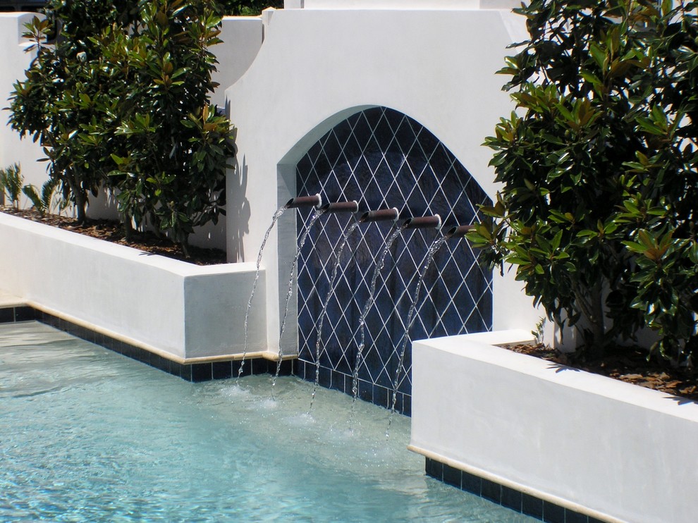 Foto de piscina con fuente mediterránea pequeña rectangular en patio con suelo de baldosas