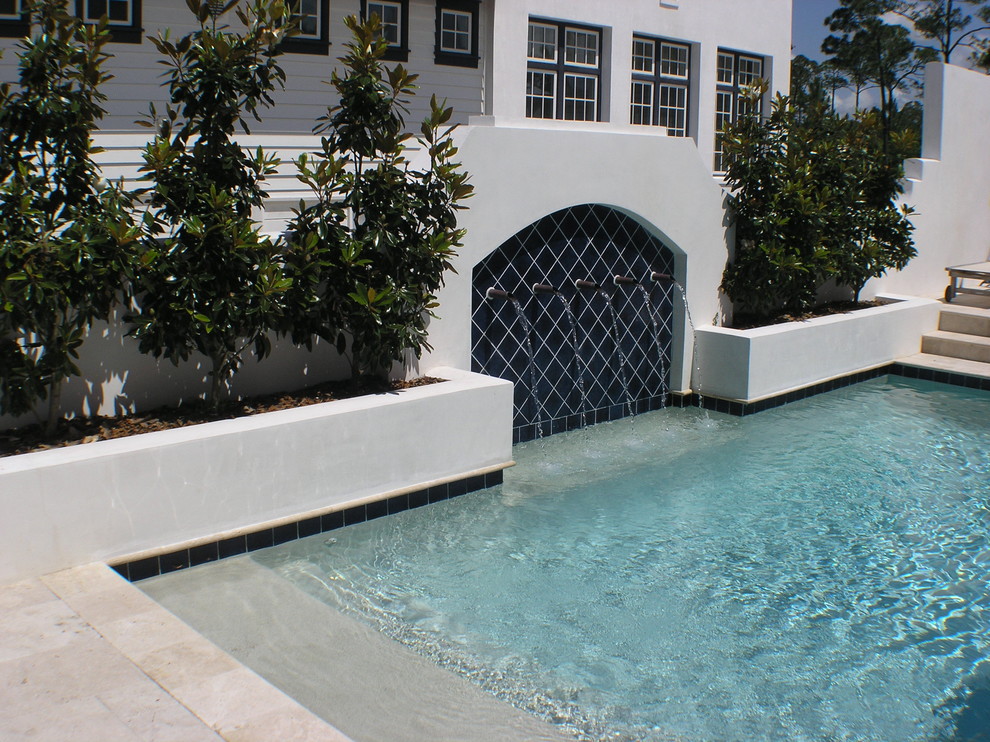 Imagen de piscina con fuente alargada mediterránea pequeña rectangular en patio con suelo de baldosas