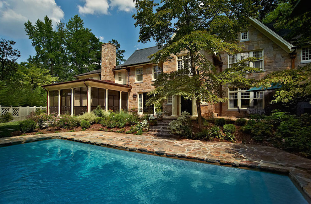 Modelo de piscina infinita clásica de tamaño medio rectangular en patio trasero con adoquines de piedra natural