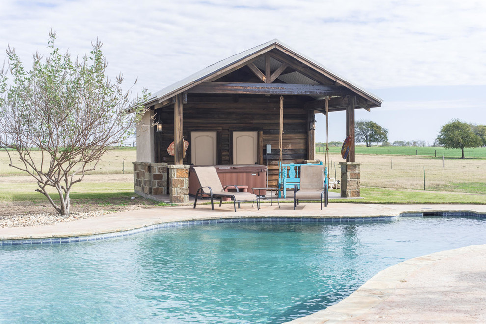 Pool house - large rustic backyard stamped concrete and custom-shaped pool house idea in Austin