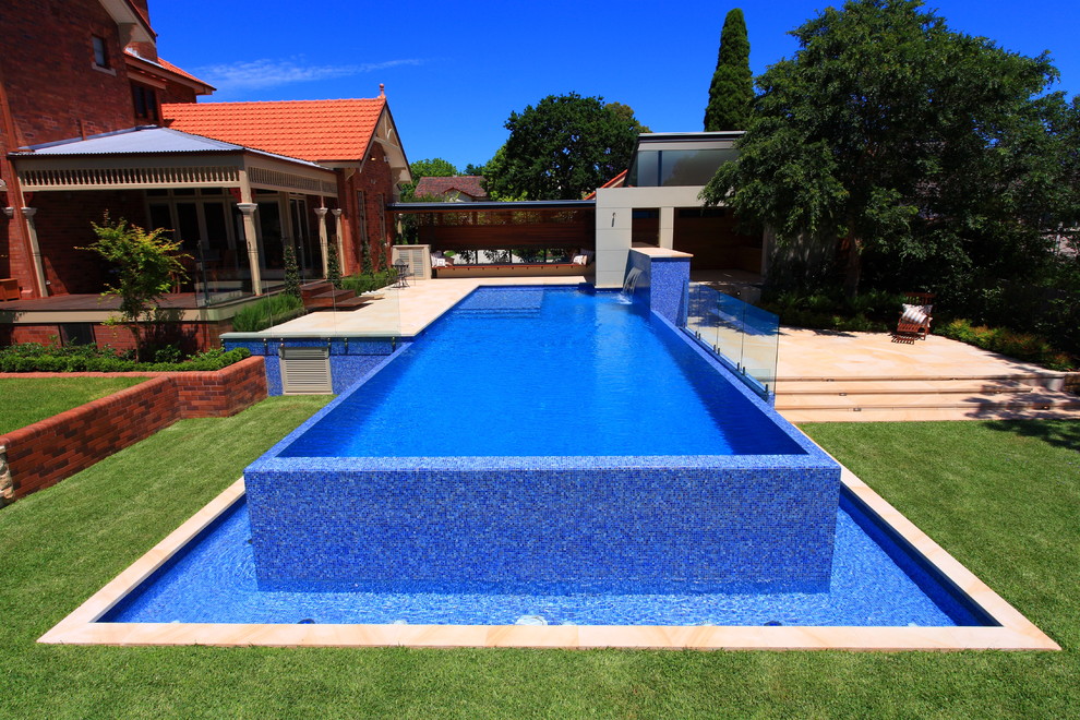 Design ideas for a medium sized modern back rectangular lengths swimming pool in Sydney with natural stone paving.