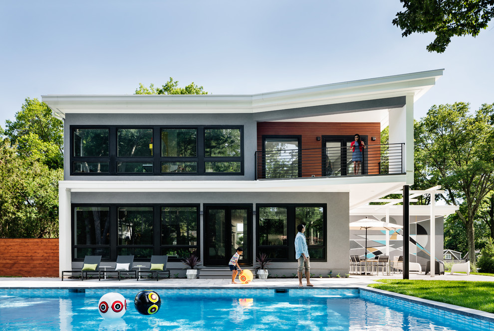 Idee per una grande piscina contemporanea rettangolare dietro casa con pavimentazioni in pietra naturale