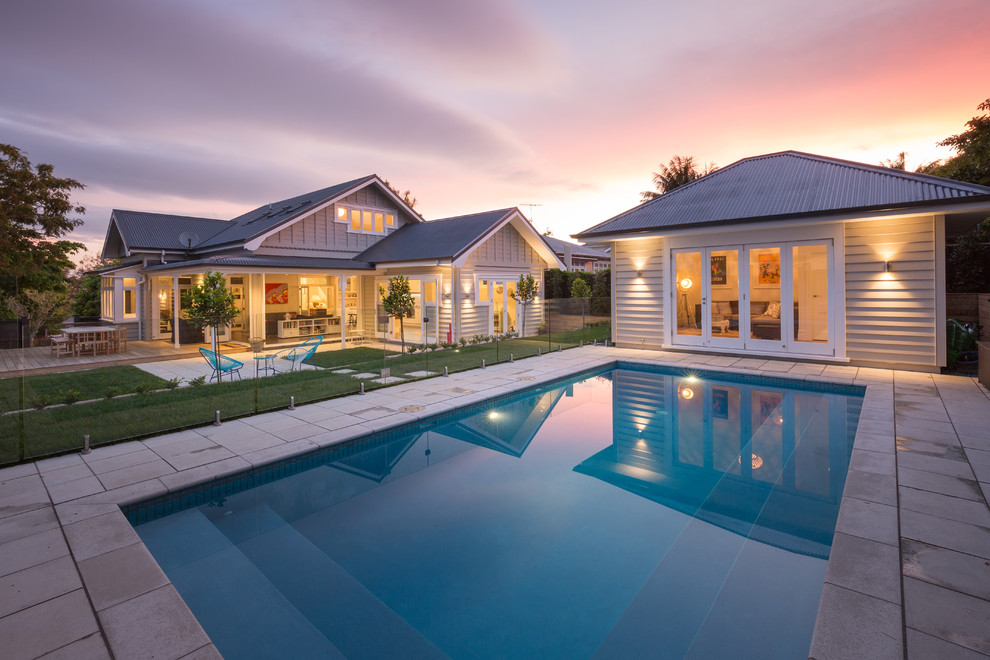 Ejemplo de casa de la piscina y piscina clásica rectangular en patio trasero