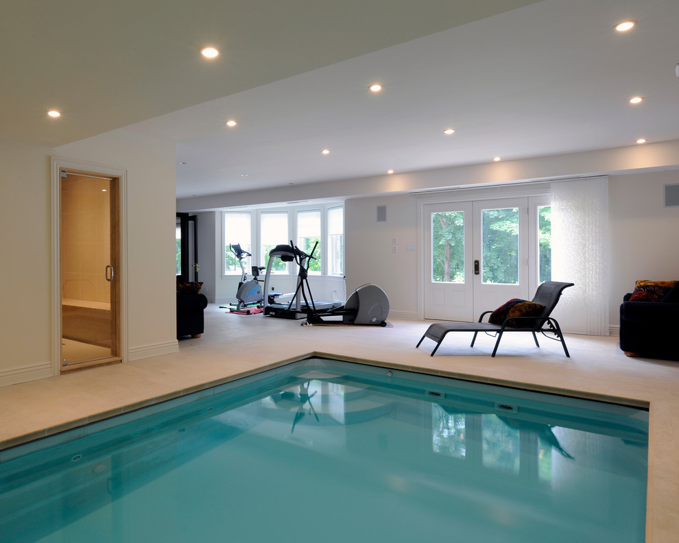 Foto de piscina alargada clásica renovada grande interior y rectangular con adoquines de piedra natural