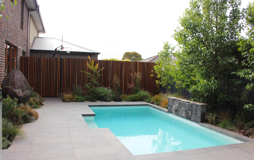 На фото: прямоугольный бассейн среднего размера на внутреннем дворе в стиле фьюжн с покрытием из каменной брусчатки с