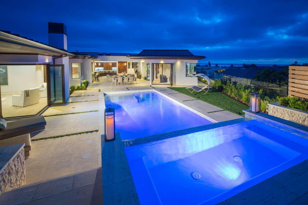 Esempio di una grande piscina monocorsia minimalista rettangolare dietro casa con piastrelle e una vasca idromassaggio