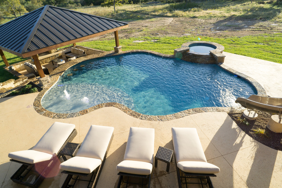 Example of a large mountain style backyard stone and custom-shaped pool fountain design in Austin