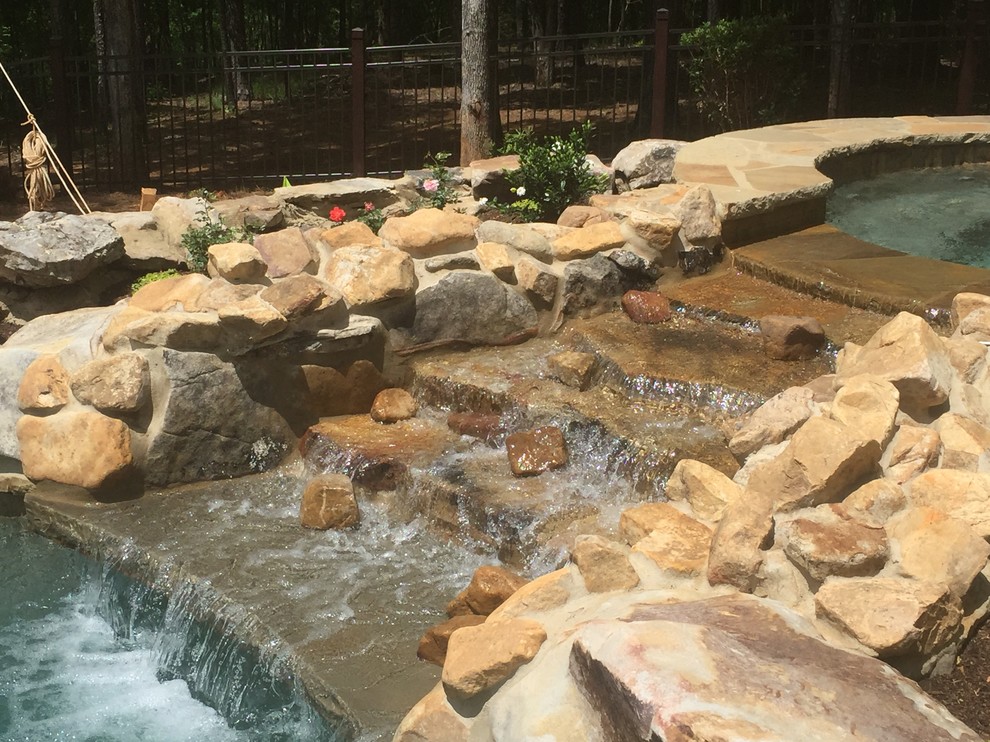Idee per una piscina naturale rustica personalizzata di medie dimensioni e dietro casa con una vasca idromassaggio e pavimentazioni in pietra naturale