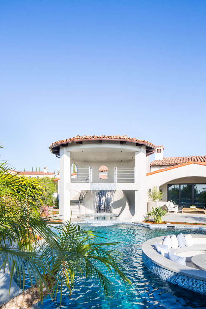 Esempio di un'ampia piscina mediterranea personalizzata dietro casa con una dépendance a bordo piscina