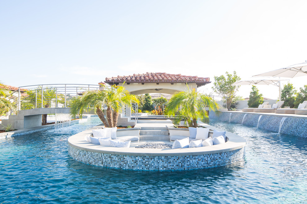 Example of a huge tuscan backyard custom-shaped pool house design in San Diego