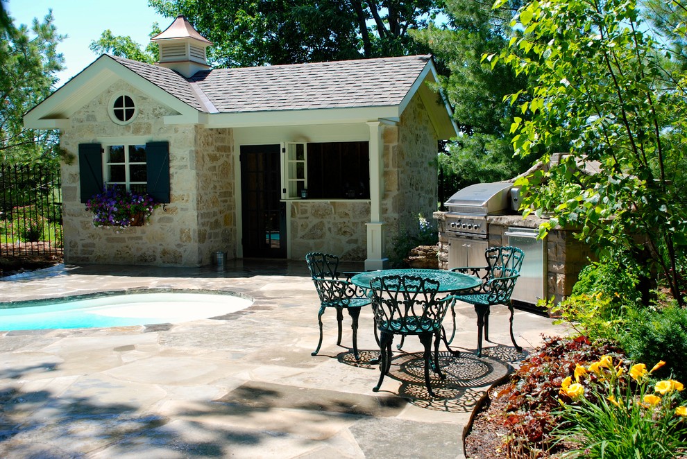 Pool house - mid-sized traditional backyard stone and kidney-shaped lap pool house idea in Toronto