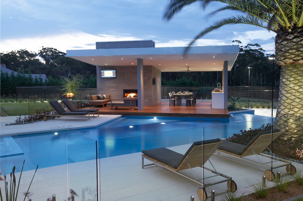 Стильный дизайн: большой бассейн-инфинити произвольной формы на заднем дворе в стиле модернизм с домиком у бассейна - последний тренд