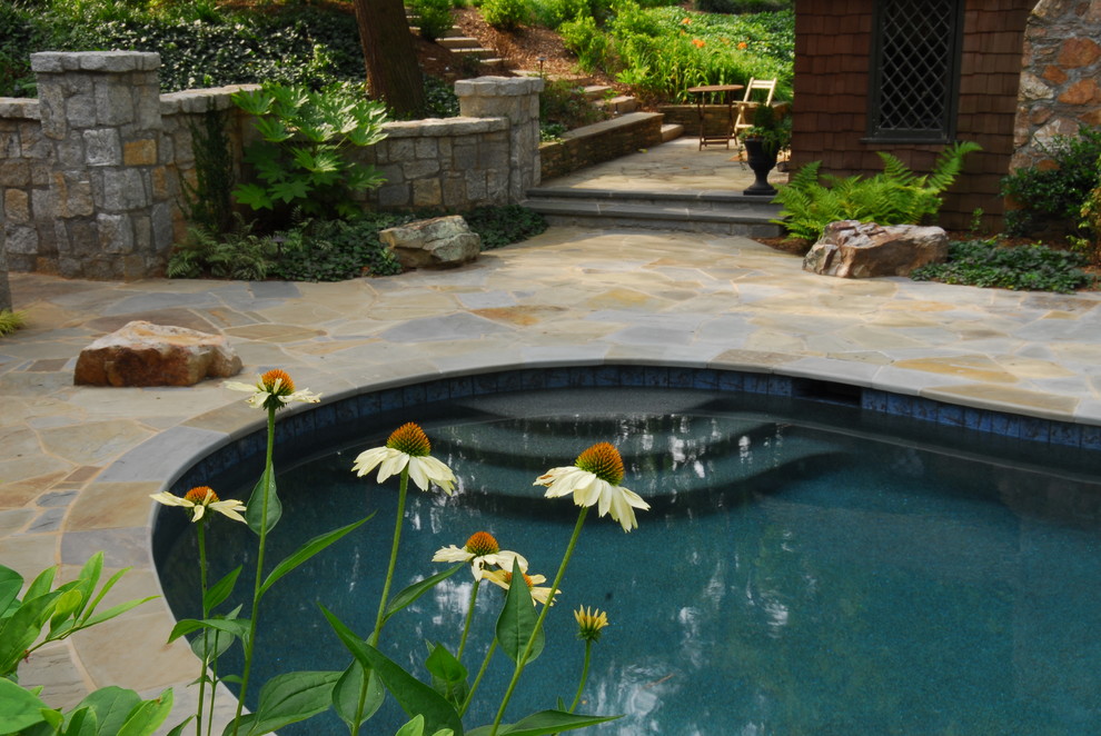 Пример оригинального дизайна: бассейн на заднем дворе в стиле рустика с покрытием из каменной брусчатки