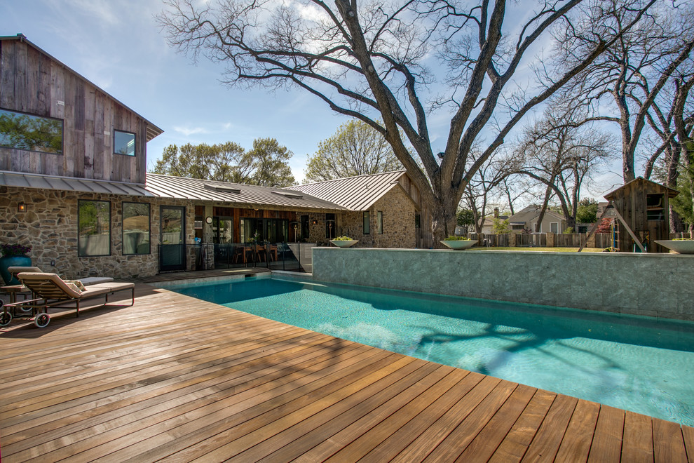 Imagen de piscina alargada de estilo de casa de campo rectangular en patio trasero con entablado