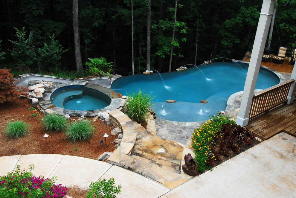 Ejemplo de piscina con tobogán infinita rústica grande tipo riñón en patio trasero