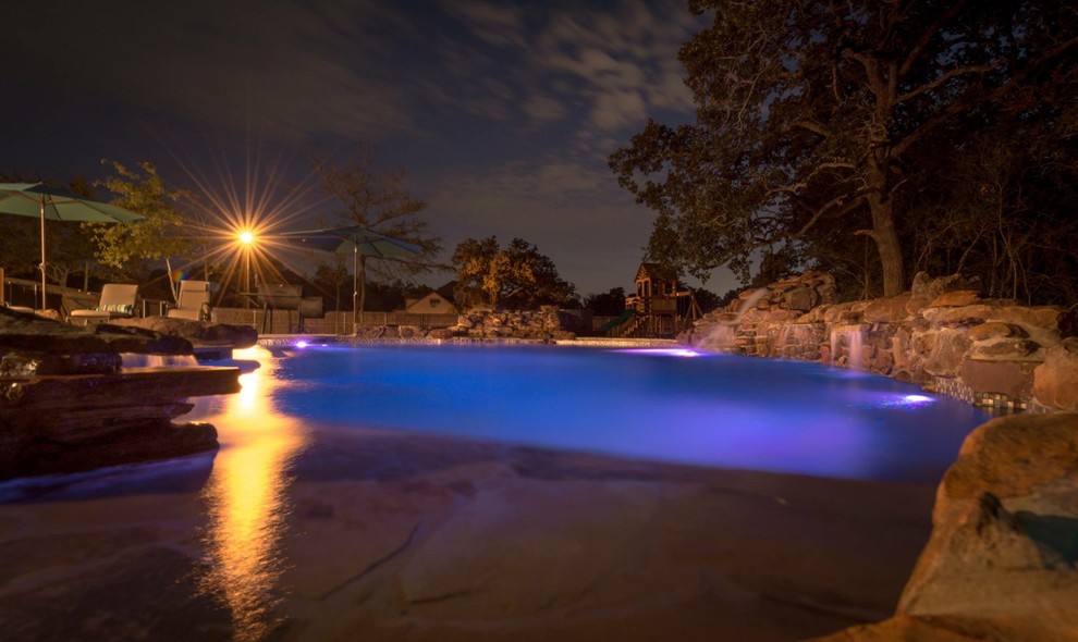 Пример оригинального дизайна: большой естественный бассейн произвольной формы на заднем дворе в стиле рустика с джакузи и покрытием из каменной брусчатки