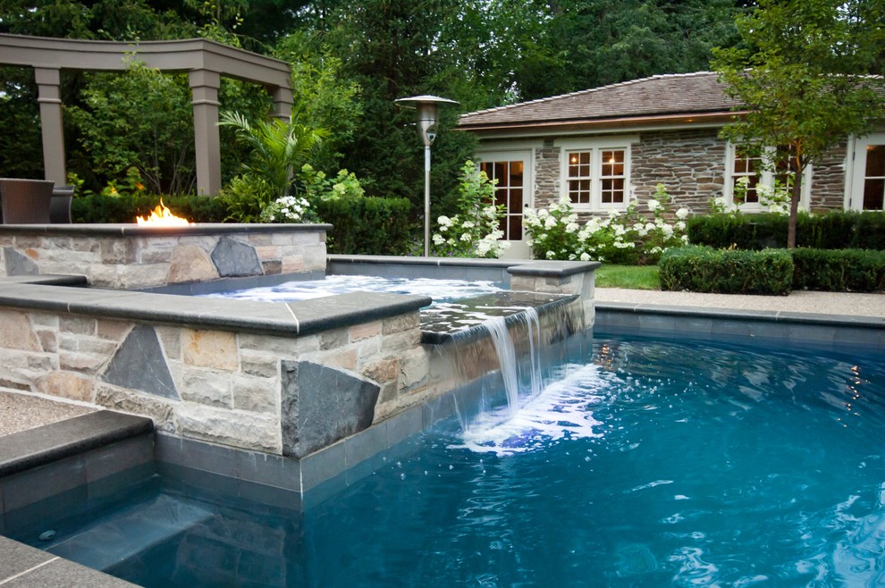 Idée de décoration pour une piscine arrière tradition avec des pavés en pierre naturelle.