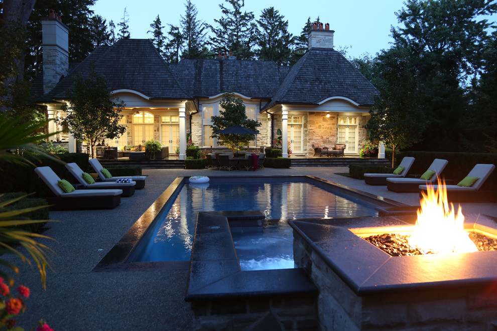 Moderner Schwimmteich hinter dem Haus in rechteckiger Form mit Wasserspiel und Natursteinplatten in Toronto