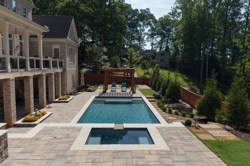 Immagine di una grande piscina naturale moderna rettangolare dietro casa con una vasca idromassaggio e pavimentazioni in cemento