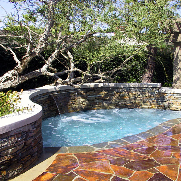 Diseño de piscinas y jacuzzis bohemios a medida en patio trasero con adoquines de piedra natural