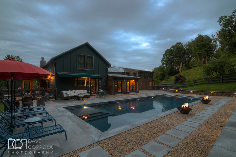 Mid-sized mountain style backyard stone and rectangular lap pool photo in New York