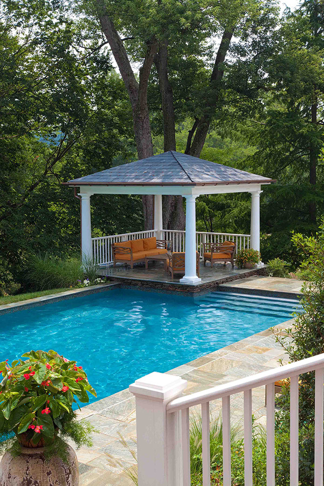 Diseño de casa de la piscina y piscina alargada clásica renovada de tamaño medio rectangular en patio trasero con adoquines de piedra natural