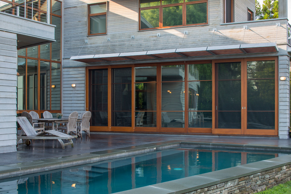 Inspiration pour un grand couloir de nage arrière design sur mesure avec une terrasse en bois.