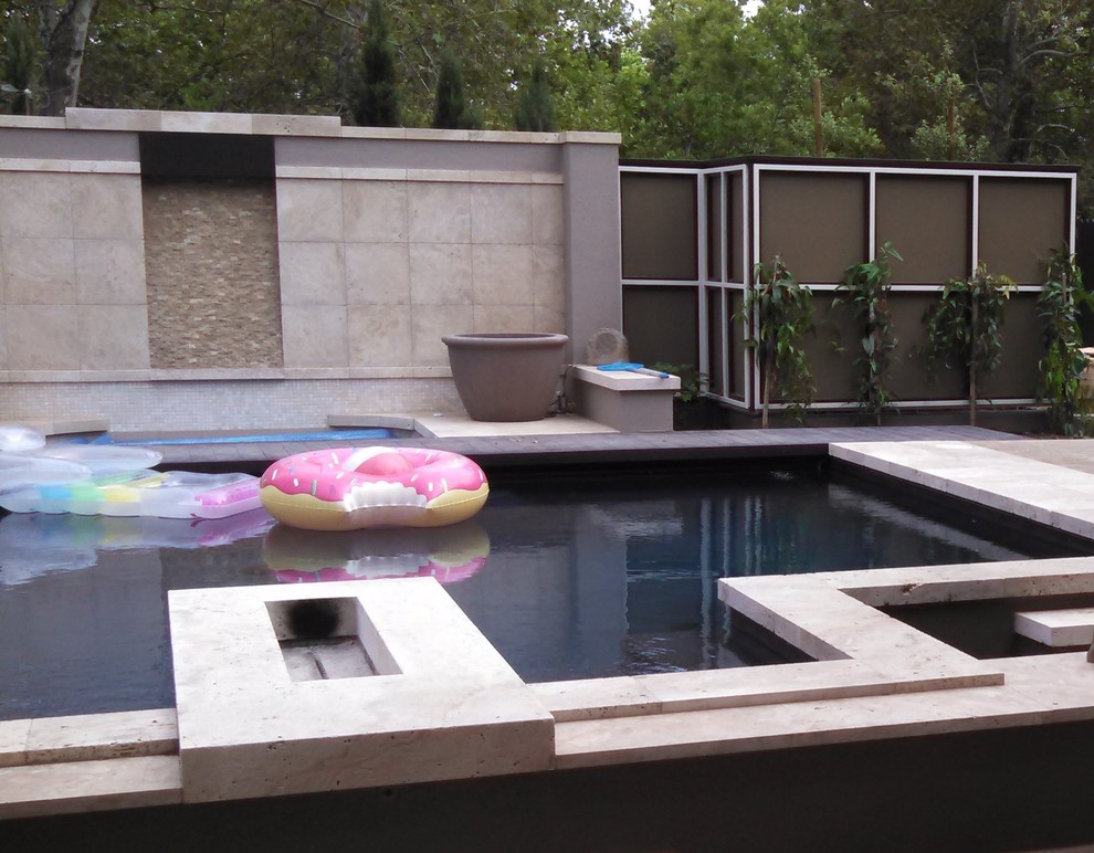 Imagen de piscina natural minimalista de tamaño medio a medida en patio trasero con suelo de baldosas